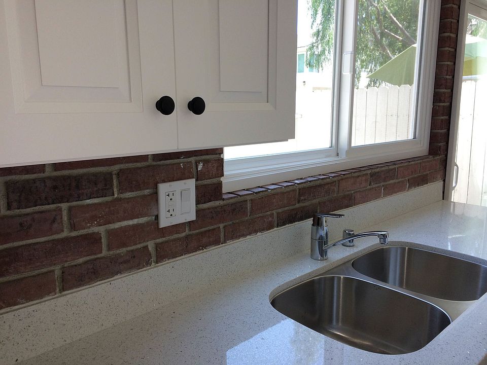 Remodeled kitchen with brick accent wall.