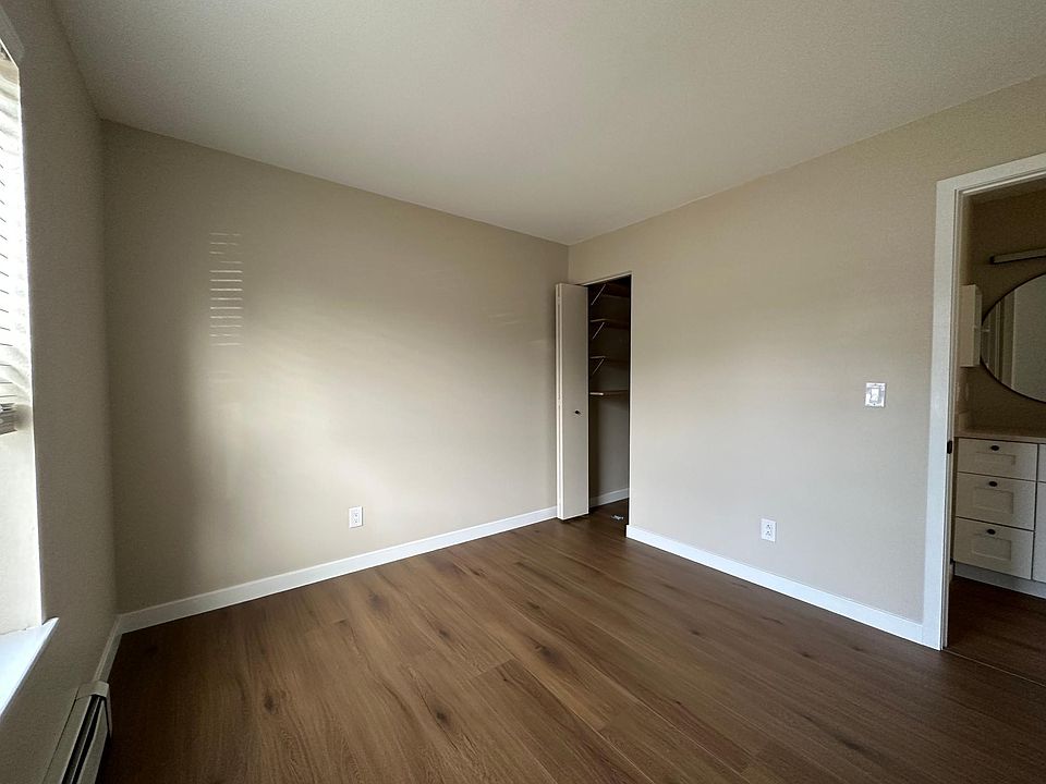 Bedroom with new flooring, fresh paint, new blinds, and two storage closets