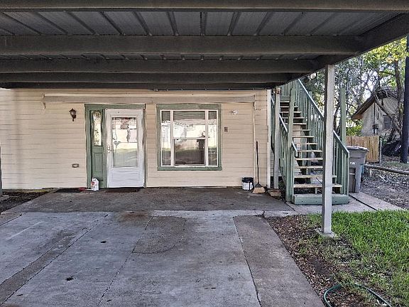 Front view under car port. Stairway to unit is on the right.