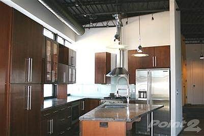 Another view of the kitchen with solid cherry cabinets-notice the natural light coming in behind them- poured concrete countertops with flecks of reclaimed metal and glass in them, Electrolux appliances