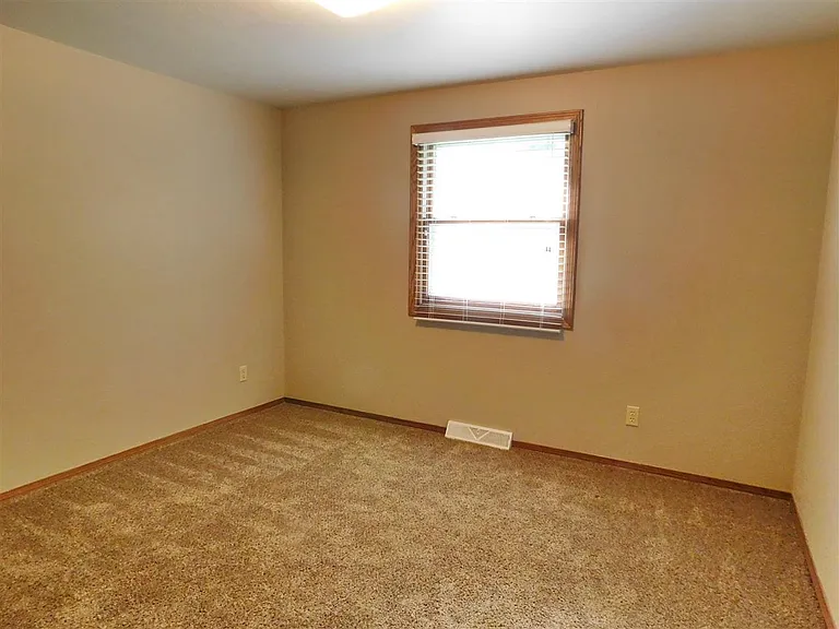 Bedroom 1 located off the kitchen. Flooring will be updated.