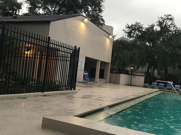 Clubhouse next to pool with sitting area and cooking area.
