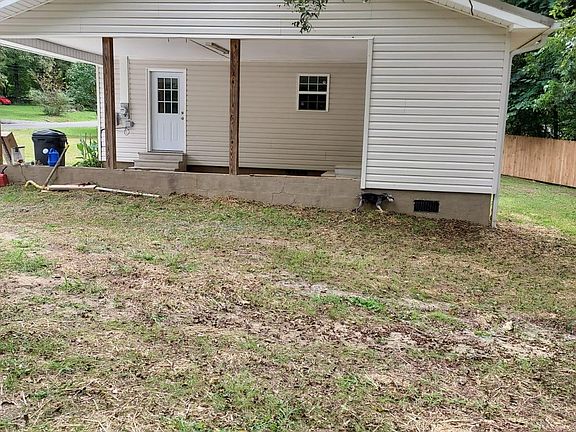 side of house with carport and fence in back yard