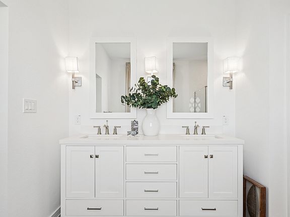 Primary bath features freestanding vanity with dual sinks
