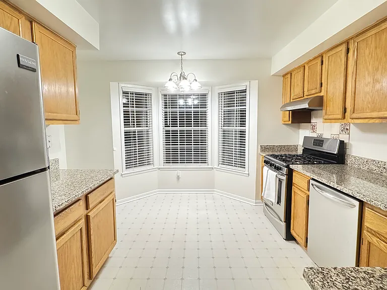 Large eat-in kitchen boasts bay window nook, granite countertops and upgraded stainless steel appliances