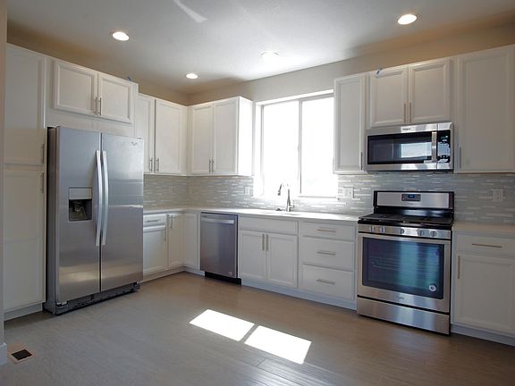 Kitchen with hardwood floors, Whirlpool appliances including gas stove.