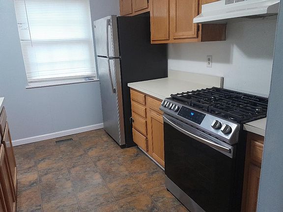 View of the kitchen from the first landing, with stainless steel refrigerator and stainless steel gas stove