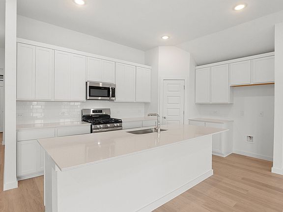 Kitchen in the Brazos home plan by Trophy Signature Homes - REPRESENTATIVE PHOTO