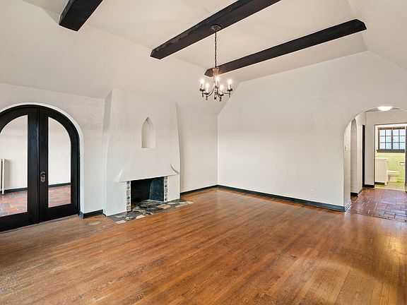 Living room with double wood and glass doors leading to the second bedroom.