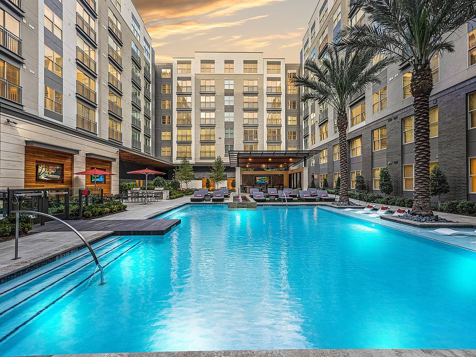 Representational Image of Resort-Style Pool with Raised Fountain, Terraced Seating, and Outdoor Dining/Grilling Areas
