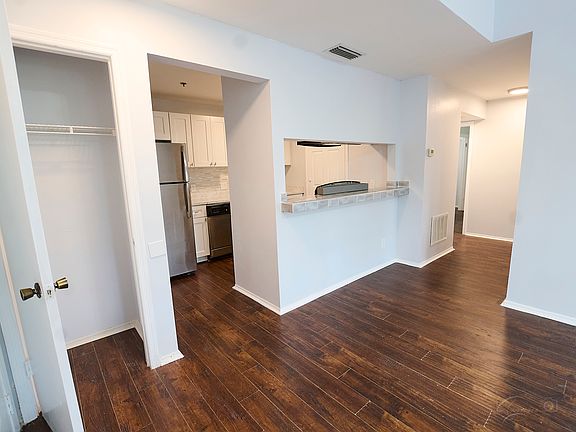 entrance door on left. This is the view of the living room, looking into the kitchen, the hallway to the right leads to the two bedrooms and bathroom.. There is also a coat closet next to the front door.