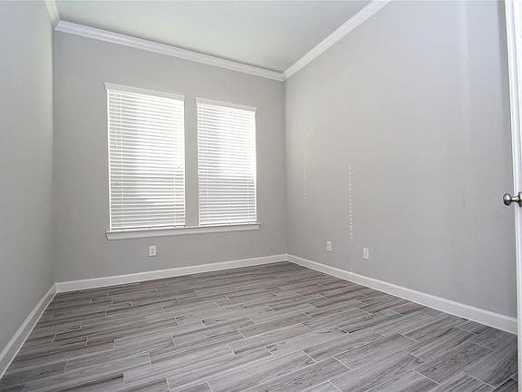 the wood look tile extends into the living room, open to the kitchen and breakfast areas