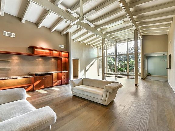 A  lighted wall of  built-ins creates decorative storage and also accomodates  audio visual equipment.