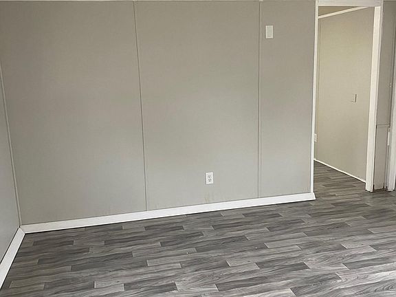 Living room with new flooring, fresh paint and baseboard mouldings.
