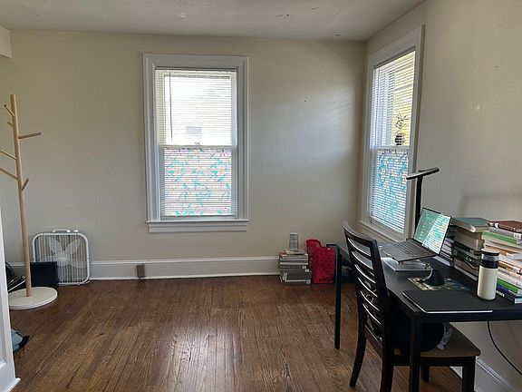 Large front room often used as the living or entertainment room plus office area, or in this case, a bedroom with an office space. This is the largest and brightest room in the apartment with four windows wrapping around the front corner of the building.