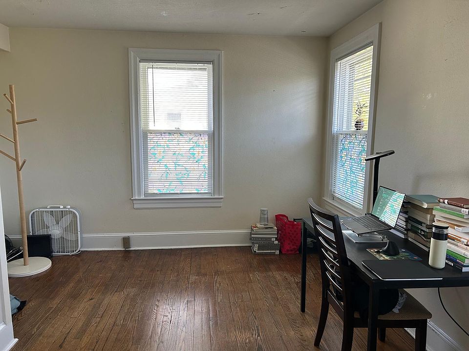 Large front room often used as the living or entertainment room plus office area, or in this case, a bedroom with an office space. This is the largest and brightest room in the apartment with four windows wrapping around the front corner of the building.