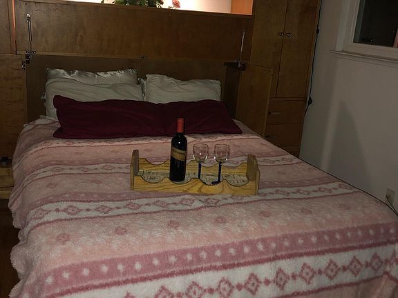 This bedroom is located in the front left of the home. There is large cabinet for hanging close and storage. A closet is also in the room with a TV stand with storage as well.