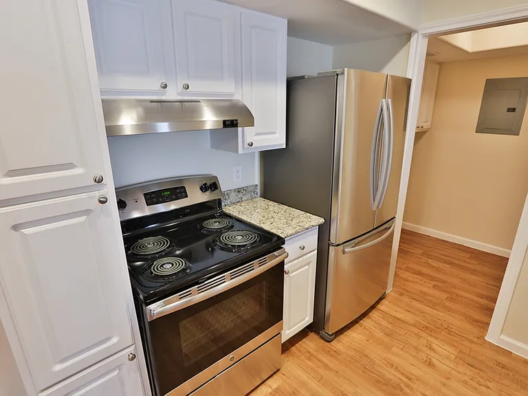 Contemporary kitchen with stainless steel appliances, sleek countertops, and elegant white cabinetry. Contemporary kitchen with stainless steel appliances, sleek countertops, and elegant white cabinetry.