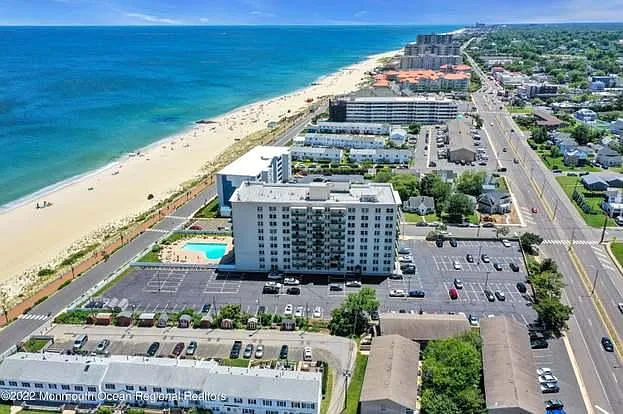 Aerial view of The Anchorage building, parking lot, and pool. Includes 3 parking spots: 1 reserved, 2 guest.