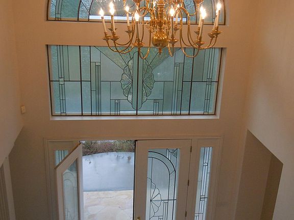 cathedral ceiling entrance hall with art glass doors and windows