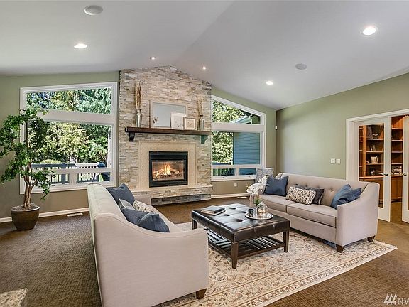 Vaulted ceilings and full height windows open to towering Douglas Firs and large back yard. The custom mantle and stacked stone fireplace provide a stunning accent. 
