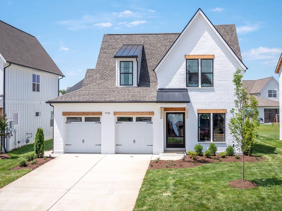 Exterior of home with white painted brick front exterior with black windows and cedar accents