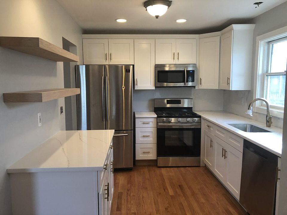 Kitchen w shaker cabinets, SS appliances and quartz countertops.