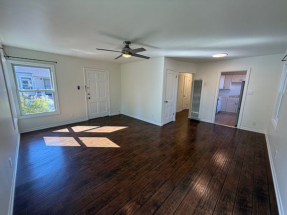 Bright, airy living room features multiple windows and hard surface flooring throughout.