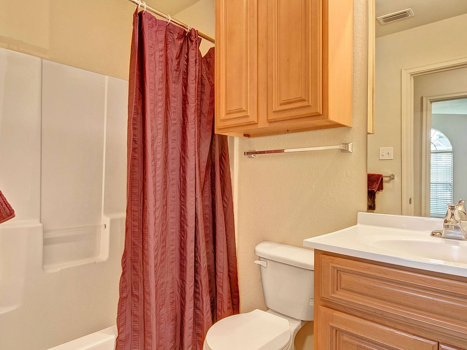 A bathroom with a bathtub and shower combination and additional cabinet storage