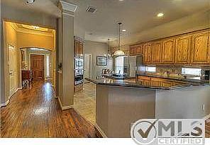 The entry leads through the house with warm, solid hand-scraped