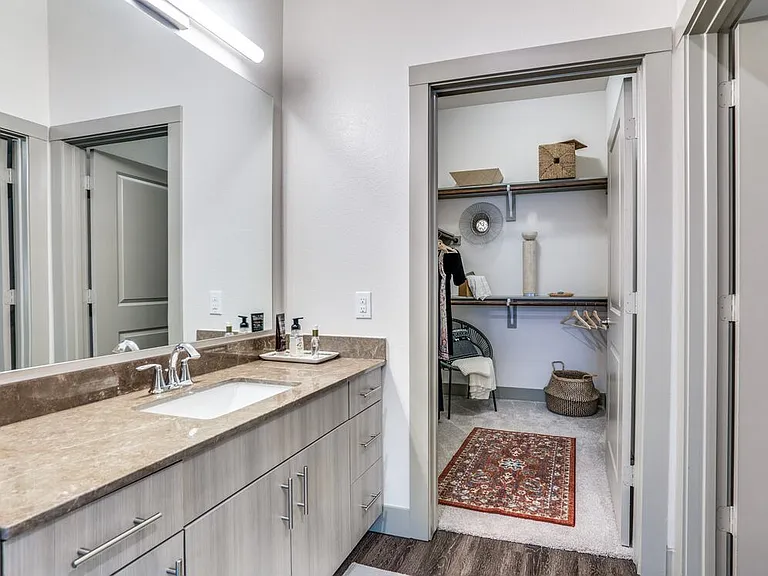 Gray finish package bath with brown granite countertop and hard surface flooring