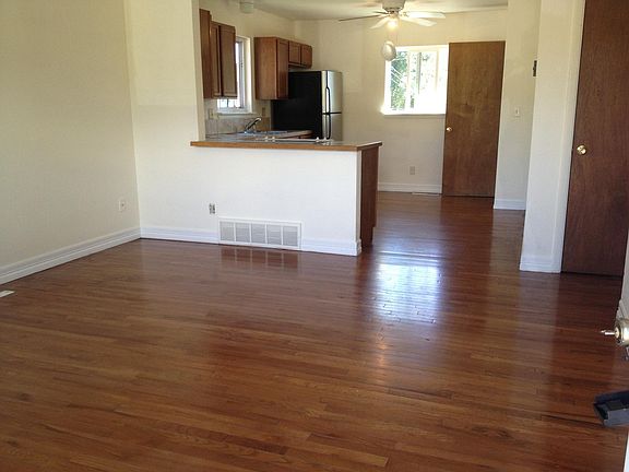 large living room looking into kitchen with hardwood floors