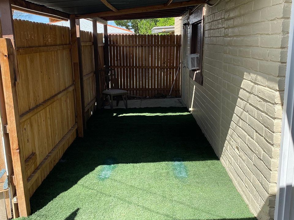 Fenced, covered yard with synthetic grass