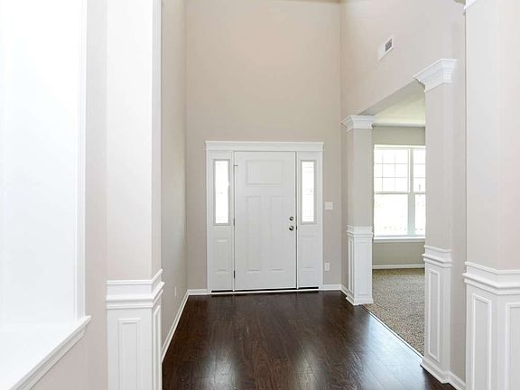 Volume foyer is beautifully trimmed out with columns and custom trim work.