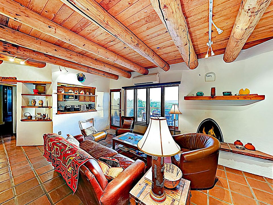 Livingroom with western view through large window and kiva fireplace.