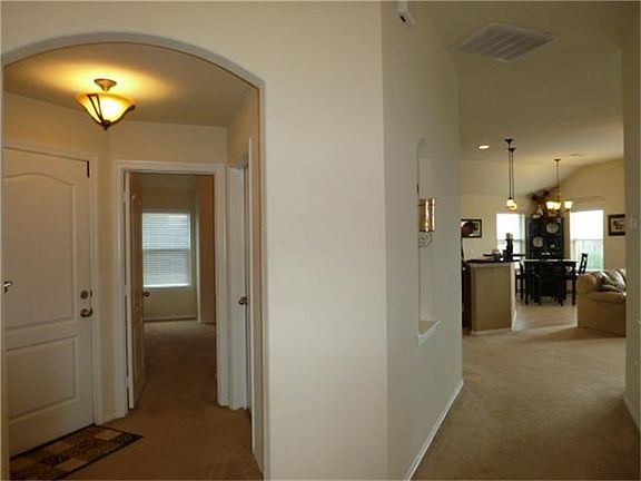 View when entering shows entry to family room area and left access to garage entry & bedrooms 2 & 3.