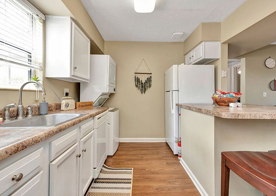 Spacious Kitchen with Ample Counter Space and Stacked Laundry Machines at The Commons Student Apartments in Oxford, OH