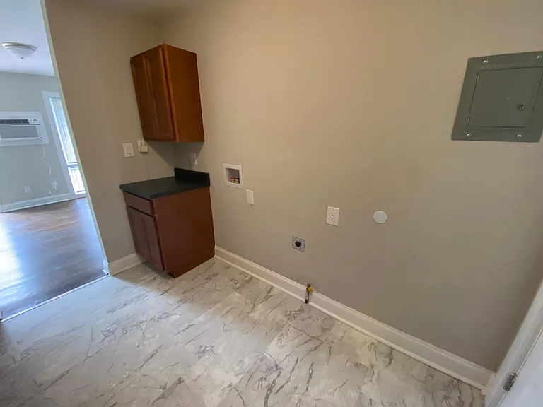 Kitchen area that has the washer and dryer hook up.