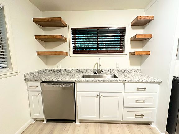 Brand new custom kitchen cabinets, open shelves, granite counter tops, dishwasher, fixtures, and new LVP flooring throughout.