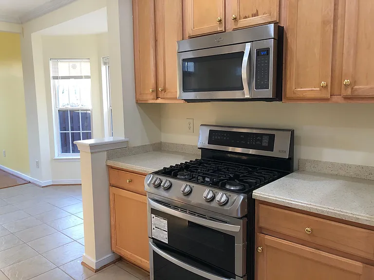 Kitchen with maple wood cabinets and gas powered cooking range.
