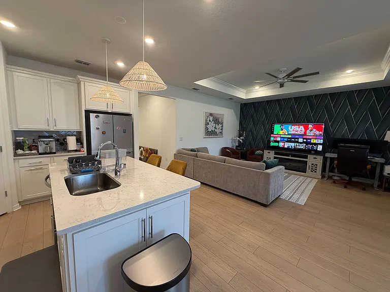 Open-concept kitchen and living area with a large island, ample cabinetry, and a spacious lounge setup for relaxing.