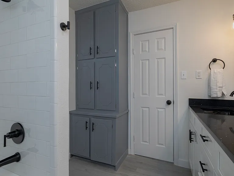 Full bathroom with double sinks and shower-tub combo attached to bedroom 1.