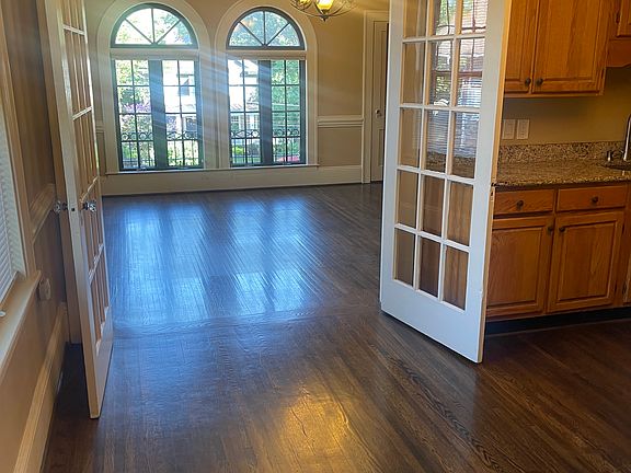 french doors leading from dining room kitchen in to living room. large windows allow for light in room also