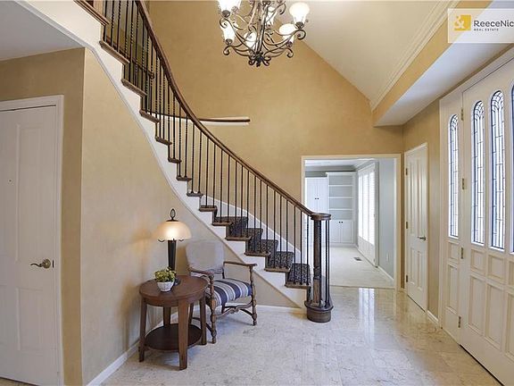Stunning entry with sweeping staircase, marble tile floor and lead glass door.