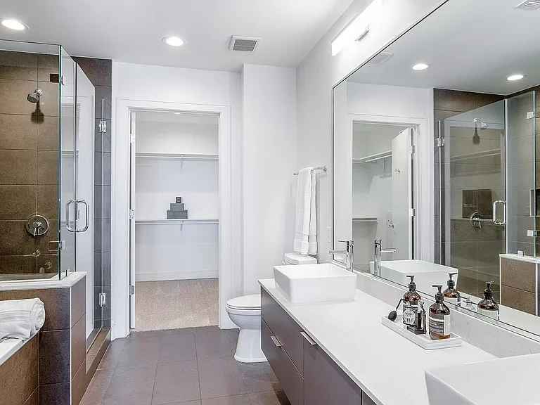 Spa-like, Modern Bathroom with Dual-Sink Vanity, Glass Enclosed Shower, and Soaking Tub.