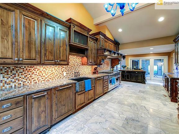 The kitchen has been completely updated with Knotty Beech cabinets and is thoughtfully appointed in every aspect.  This view showcases the custom tile backsplash and you can see the granite farm sink which offers full size dishwashers on BOTH sides of the