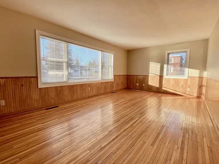 Bright spacious living room featuring elegant wood flooring and large windows for natural light. Bright spacious living room featuring elegant wood flooring and large windows for natural light.