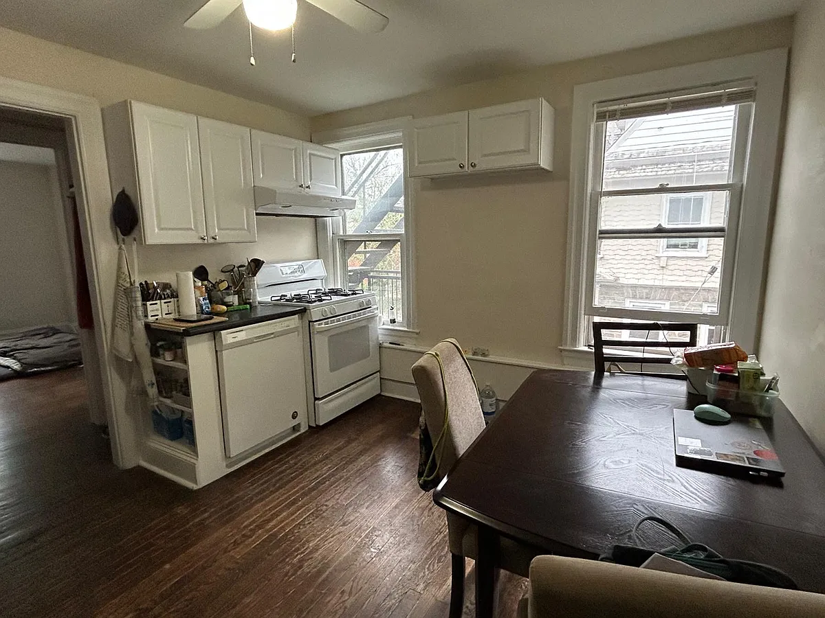Eat in kitchen with gas range, dishwasher, stainless steel restaurant grade sink & cabinet, and silver refrigerator. Shelving unit (not in photograph) available for tenant's use for under the high cabinets. - 30 Wiggins St #2