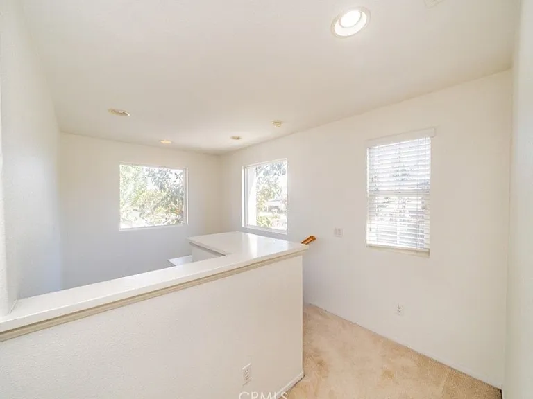 This picture shows the vaulted ceilings in this part of the house. The view is from the top story of the house, facing the stairs. Please note: Home has been upgraded with new carpet that is not shown in this picture.