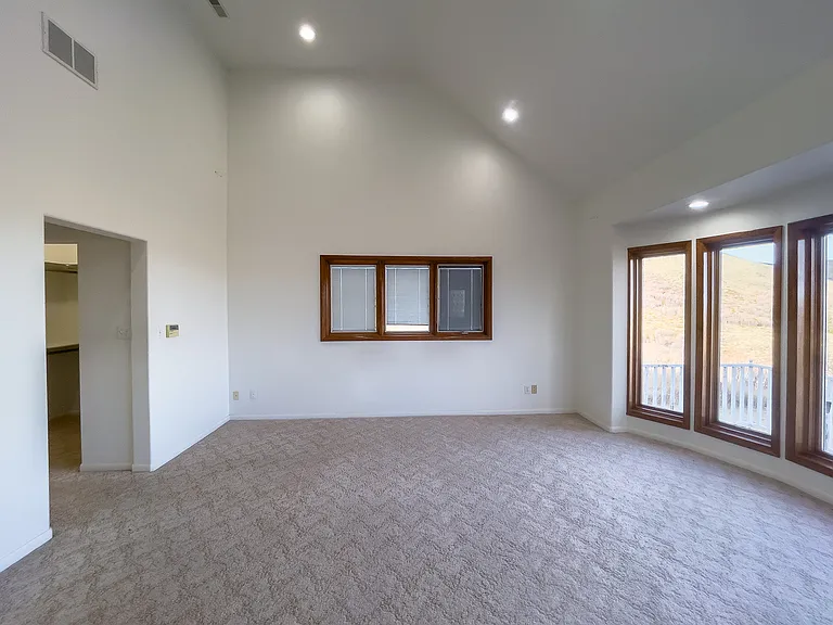 With its sweeping ceilings and graceful sense of space, this primary bedroom feels like a sanctuary, inviting calm, comfort, and quiet luxury.